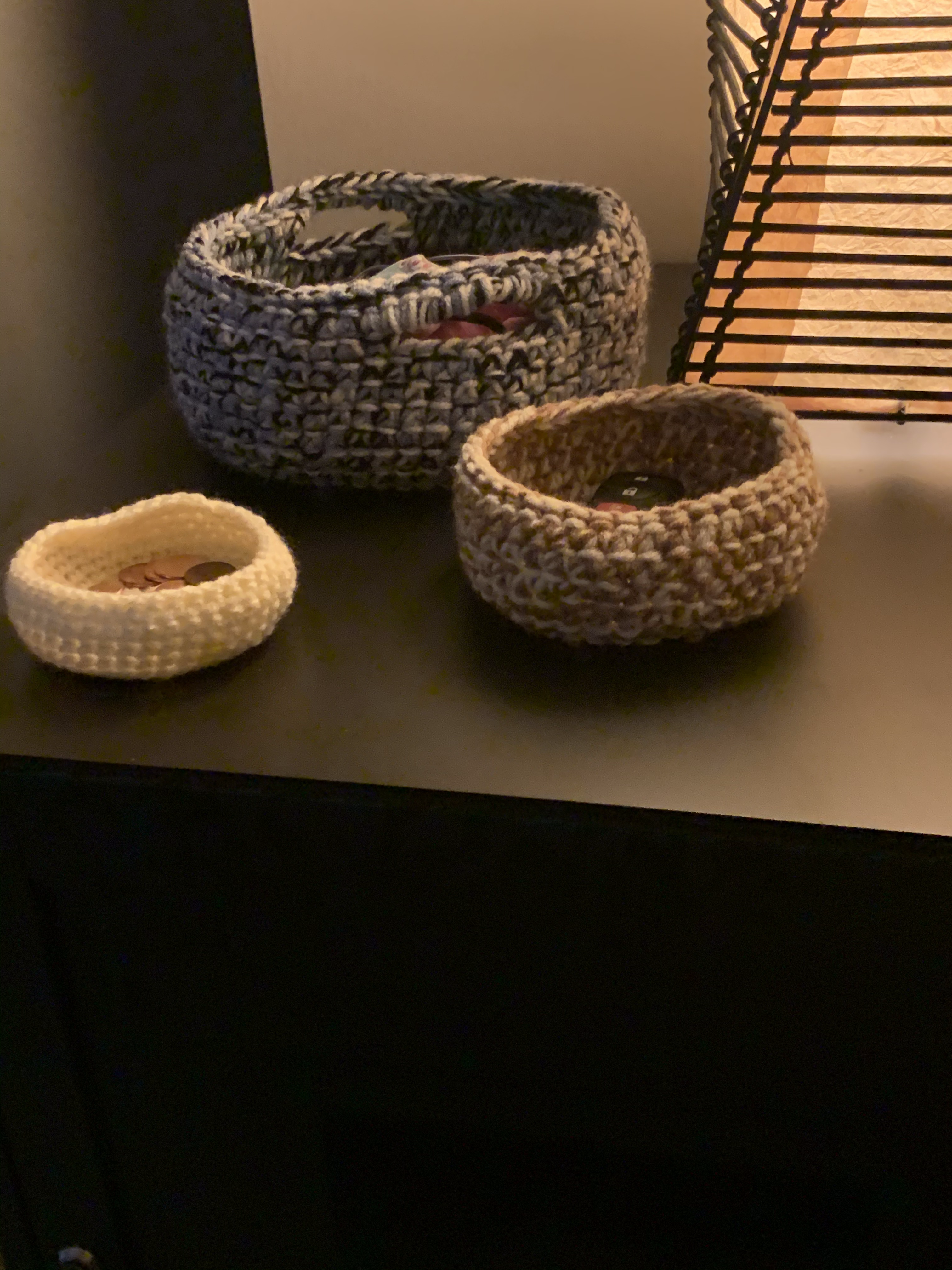 3 small, crocheted baskets, viewed from the side